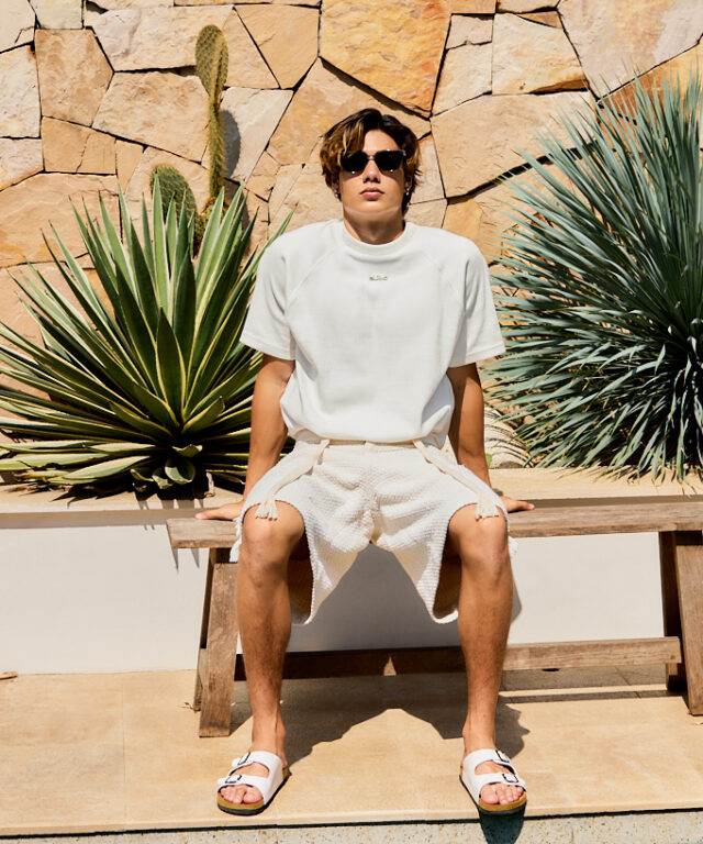 White ribbed crewneck top, featuring a metallic BLÃNC logo badge on the chest
